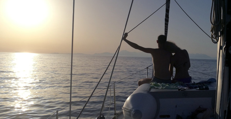 Coppia si abbraccia al tramonto sulla barca a vela