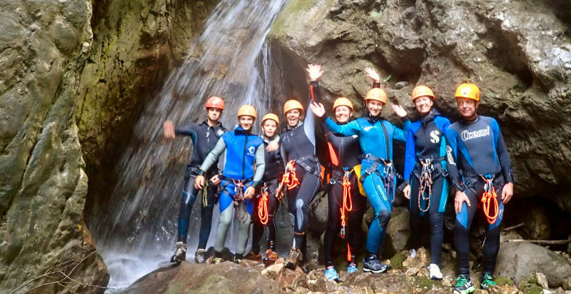 Gruppo di partecipanti che si tuffano nel fiume durante il canyoning