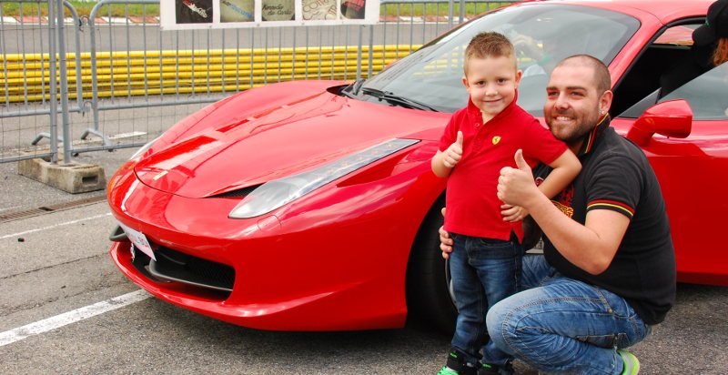 Bambino felice su Ferrari con istruttore