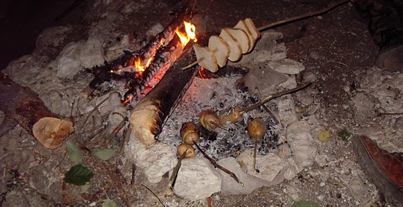 Cibo grigliato su un fuoco aperto durante un corso di sopravvivenza