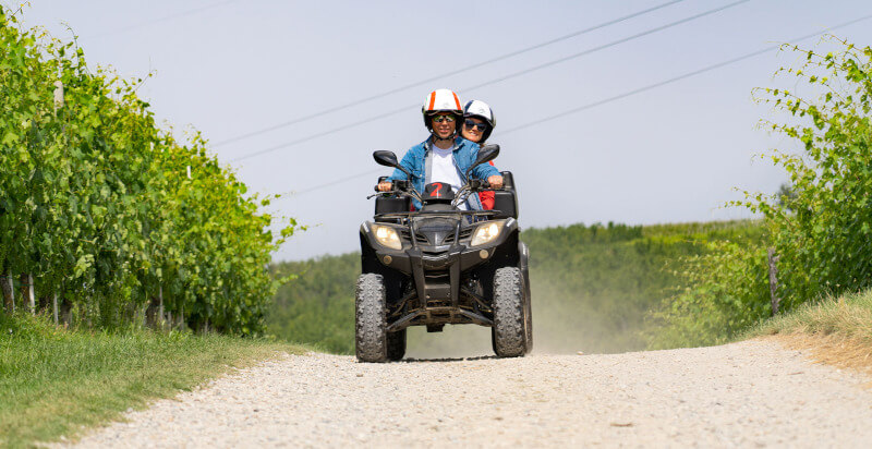 copia sul quad - conducente e passeggero con quad su strada forestale