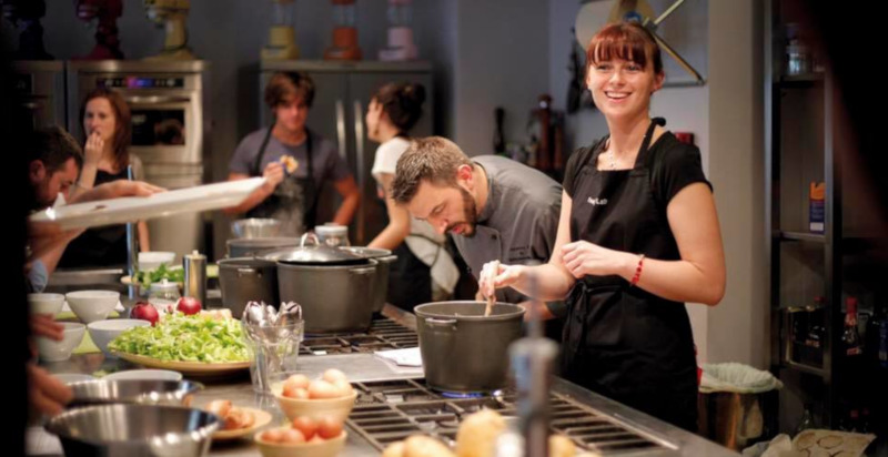 Partecipanti che cucinano durante un corso di cucina a Milano
