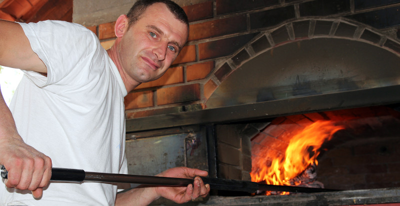 Maestro pizzaiolo che insegna a fare la pizza Margherita a Napoli