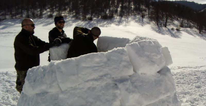Partecipanti collaborano alla costruzione di un igloo in un'esperienza di team building