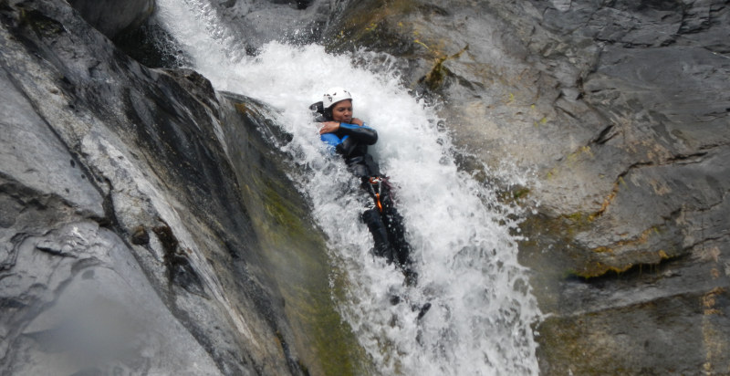 Partecipante lungo uno svivolo naturale durante il canyoning a Finale Ligure