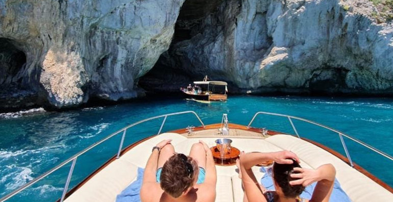 Coppia brinda al tramonto in barca a Capri
