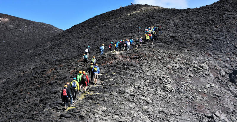 Escursionisti durante un trekking sull’Etna tra colate laviche