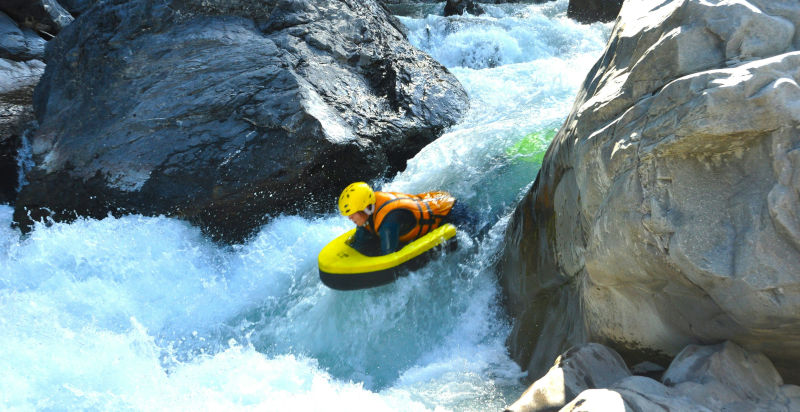 Partecipante che affronta una rapida in hydrospeed sul fiume Dora Baltea