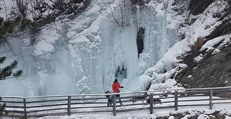Ciaspolata invernale con husky in paesaggio montano