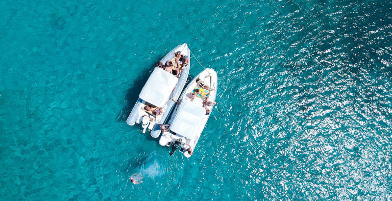 Gommone ancorato davanti a una spiaggia selvaggia della Calabria