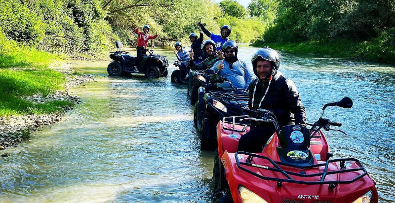 Quad che attraversa un fiume nelle Marche