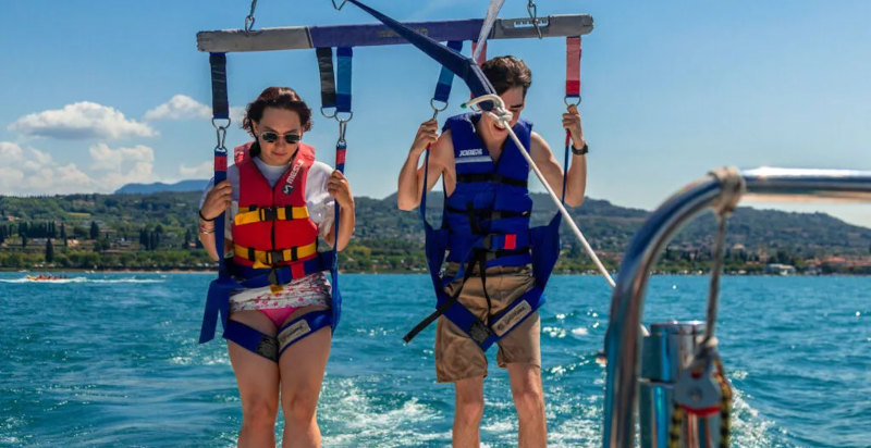 Atterraggio di una coppia dopo l'esperienza di parasailing sul lago di Garda