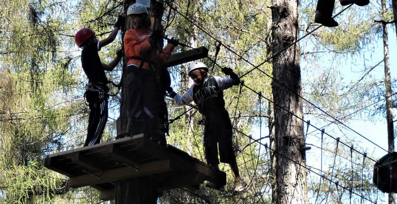 Bambini impegnti nei percorsi al parco avventura di Caldes, Trento