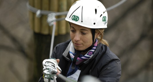 Partecipante affronta percorso a fune al parco avventura di Veglio