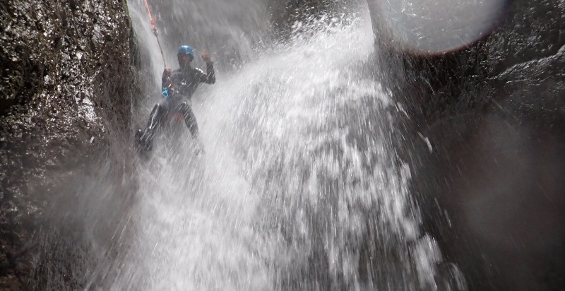 Passaggio con corde lungo una cascata durante il canyoning in val di Sole