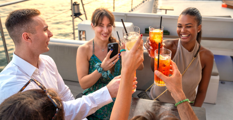 Persone che brindano durante un aperitivo in catamarano nella laguna di Venezia