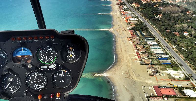 Cockpit di un elicottero R22 durante un volo sopra la costa laziale