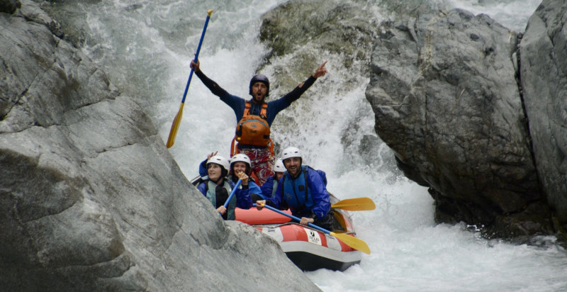 Guida esperta che accompagna un gruppo di partecipanti nel rafting