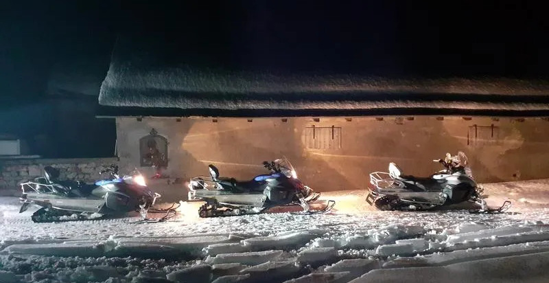 Rientro notturno in motoslitta sotto il cielo stellato