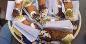 Cannolo siciliano ripieno di ricotta, pistacchi e cioccolato durante il tour gastronomico di Catania