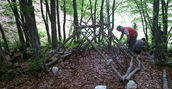 Partecipante mentre costruisce un rifugio d'emergenza durante il corso di sopravvivenza