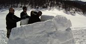 Partecipanti collaborano alla costruzione di un igloo in un'esperienza di team building