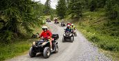 diversi quad guidati da conducenti con passeggeri sul sentiero in bosco