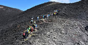Escursionisti durante un trekking sull’Etna tra colate laviche