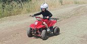 Bambino con casco e attrezzatura di sicurezza su quad elettrico