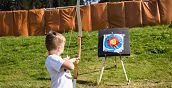Bambini che imparano a tirare con l'arco in un campo attrezzato