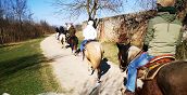 Gruppo di persone a cavallo immerso nella natura veronese