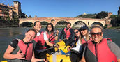 Persone sorridenti su gommone da rafting a Verona