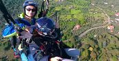 Pilota di parapendio con passeggero sorvola le colline di Tivoli