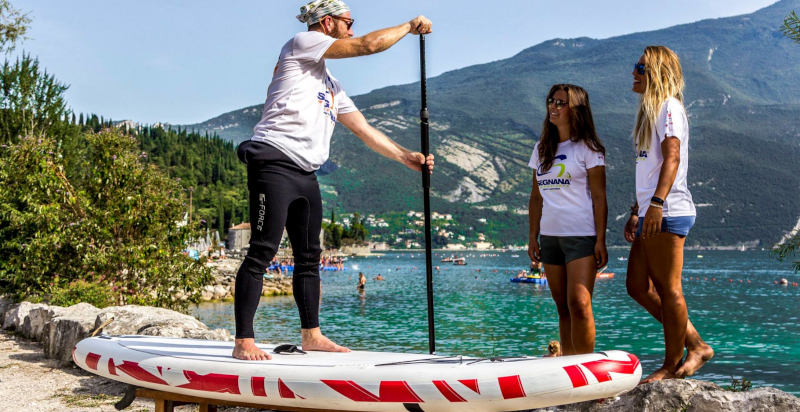 Istruttore che guida principianti durante un corso di Stand Up Paddle sul Lago di Garda