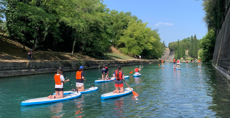 Gruppo di persone praticando stand up paddle sui canali di Peschiera