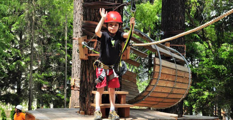 Bambini che attraversano una zipline al parco avventura a Vipiteno