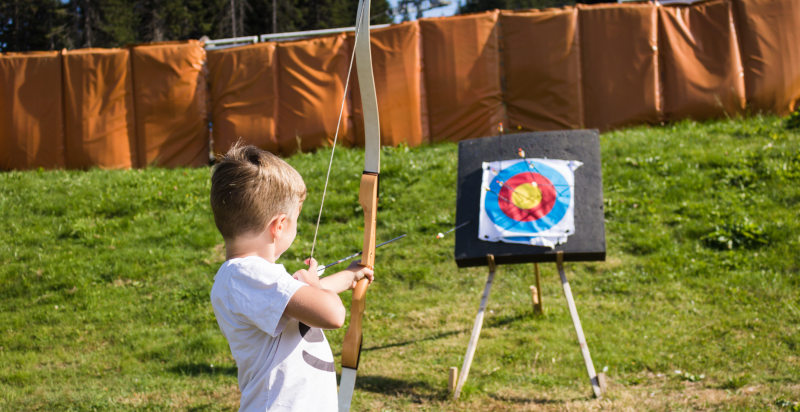 Bambini che imparano a tirare con l'arco in un campo attrezzato