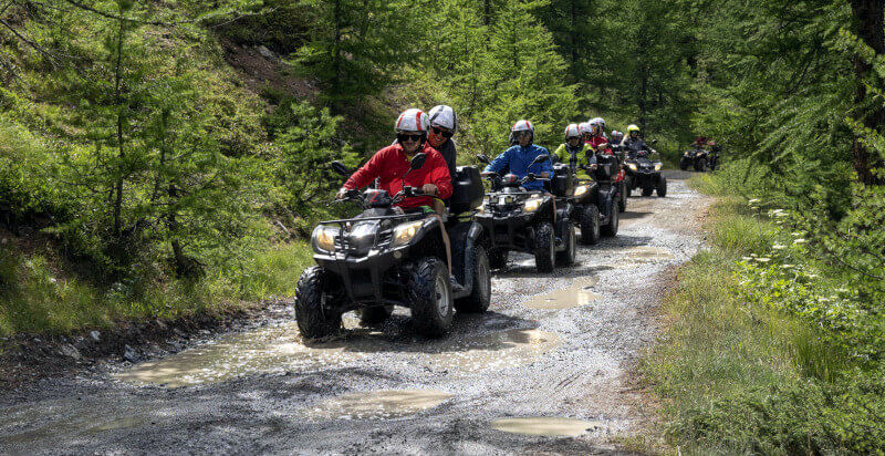 tour in quad sentiero con pozzanghere inmezzo al bosco a Sauze di Sesana