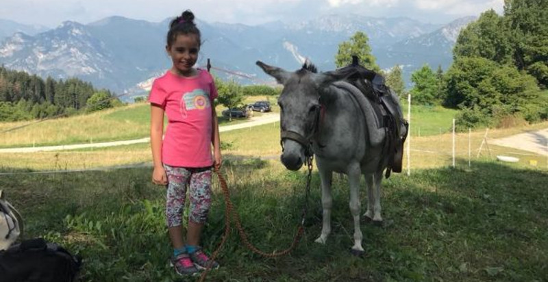 Bimba con un asinello durante il trekking ad Arco