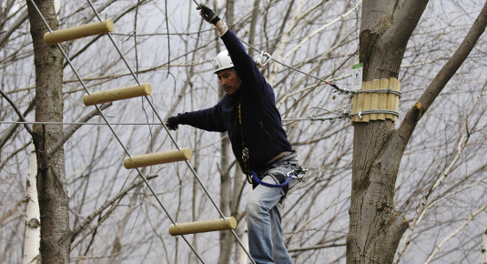 Partecipante mentre affronta un percorso sospeso ad alta fune