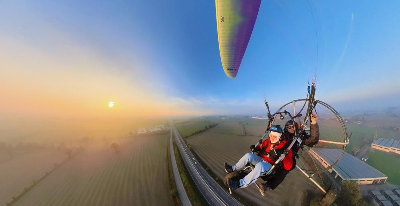 Volo biposto in paramotore al tramonto su paesaggi spettacolari