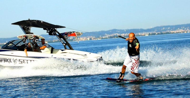 Wakeboarder trainato da un motoscafo nelle acque del Lago di Garda